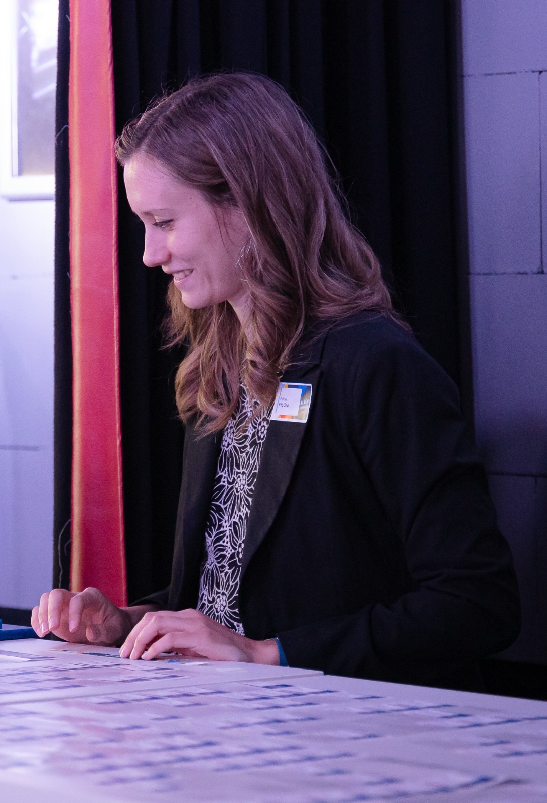 Event host greeting arrivals at a polished check-in desk.